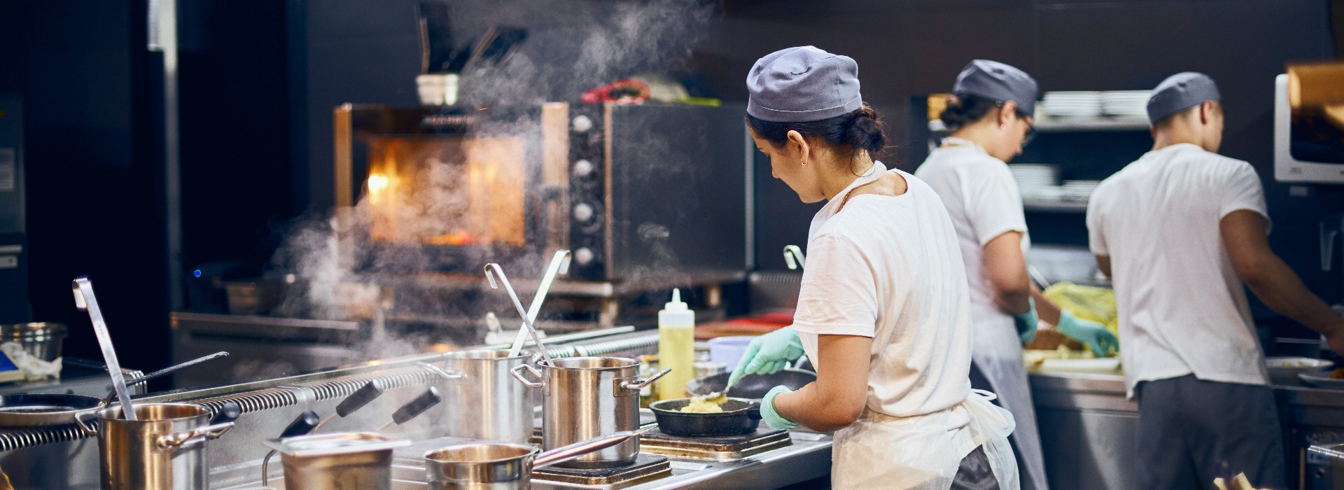 The team of cooks backs in the work in the modern kitchen the workflow of the restaurant in the kitchen copy space for text jpg